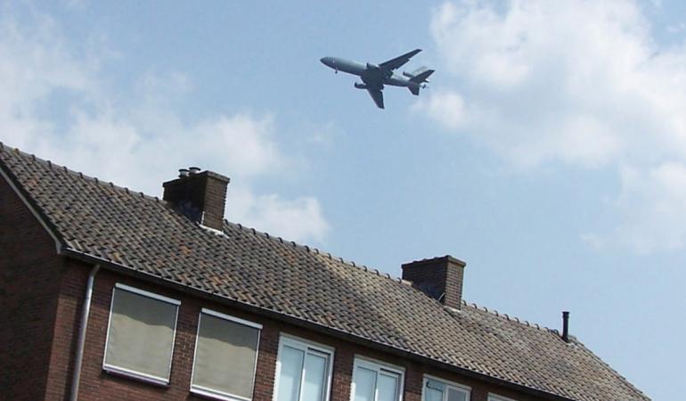 Vliegtuig boven rij huizen