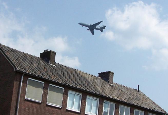 Vliegtuig boven rij huizen